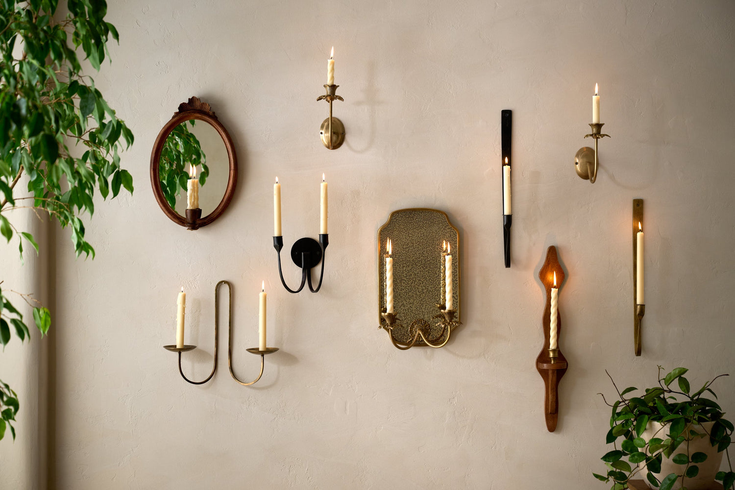 Collection of wood, bronze, and black metal wall sconces hanging on wall.