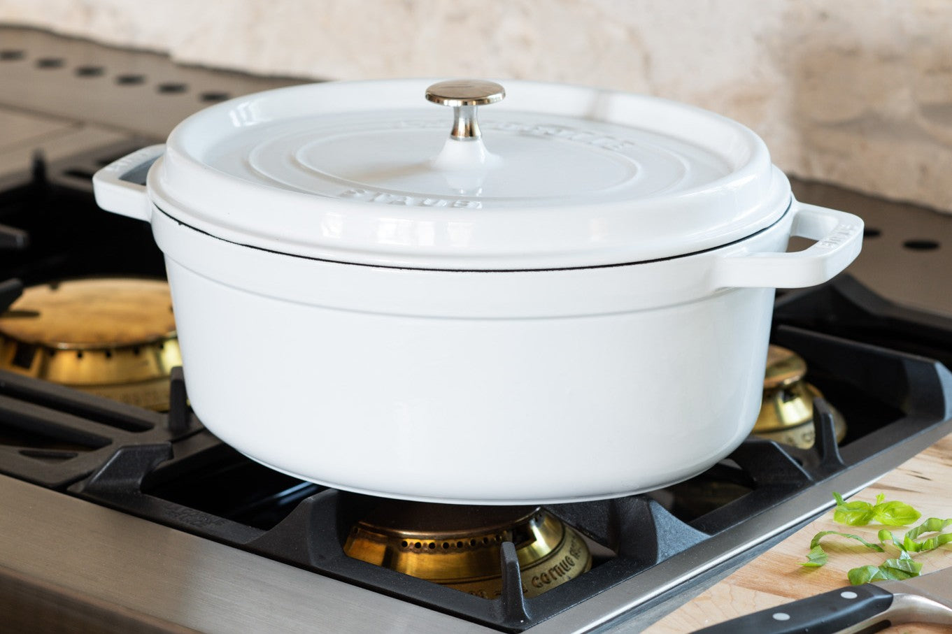 Shop cookware. Image features white dutch oven on stovetop