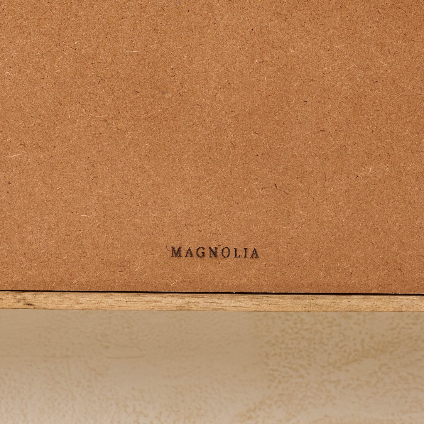 Belmar Arched Woven Wall Shelf close up of magnolia logo on the back of shelf