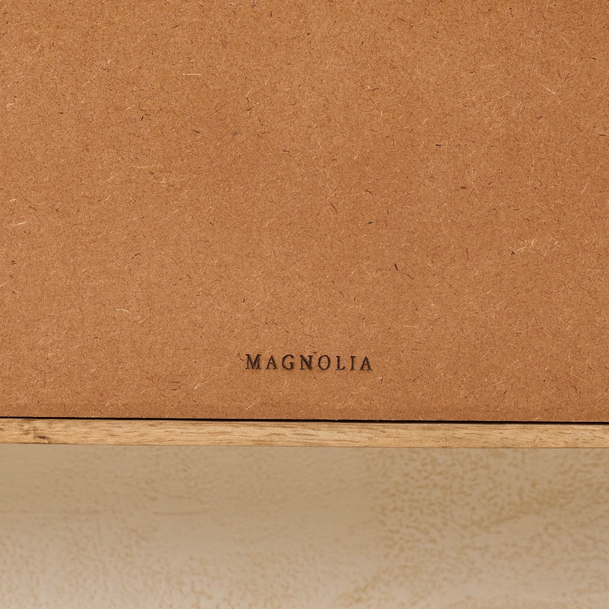 Belmar Arched Woven Wall Shelf close up of magnolia logo on the back of shelf