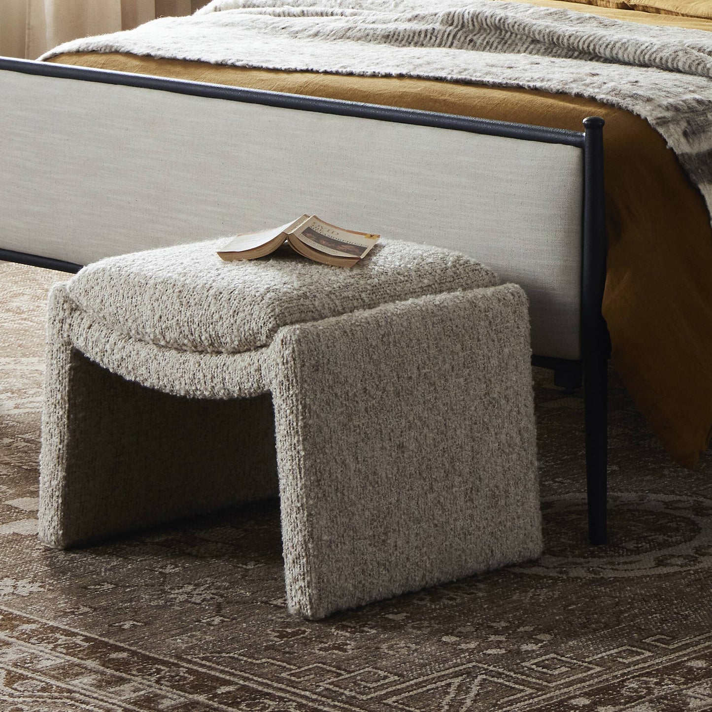Gina Boucle Ottoman shown at end of bed