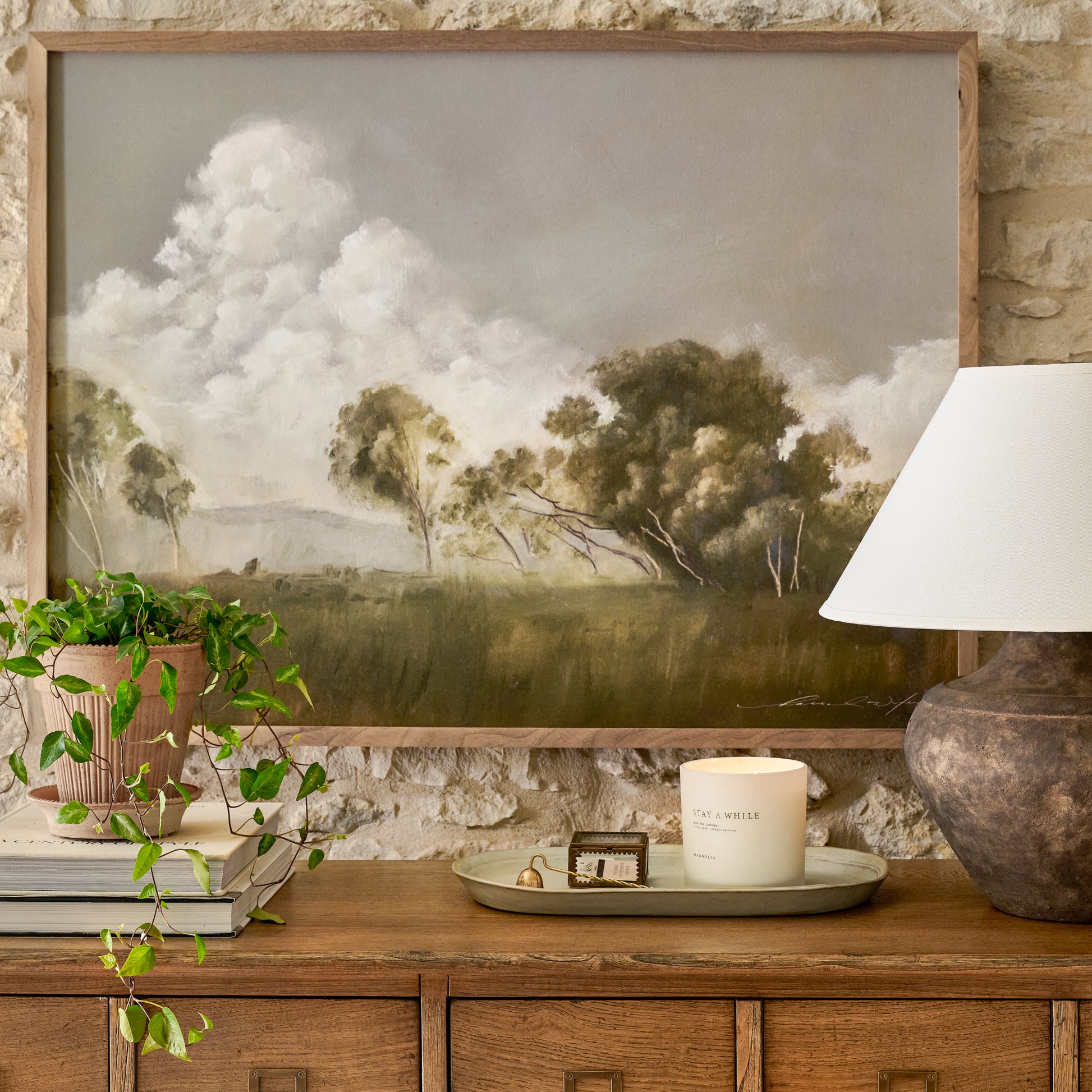 Wall art Meet Me There #5 by Hannah Winters hangs on brick wall above wood sideboard