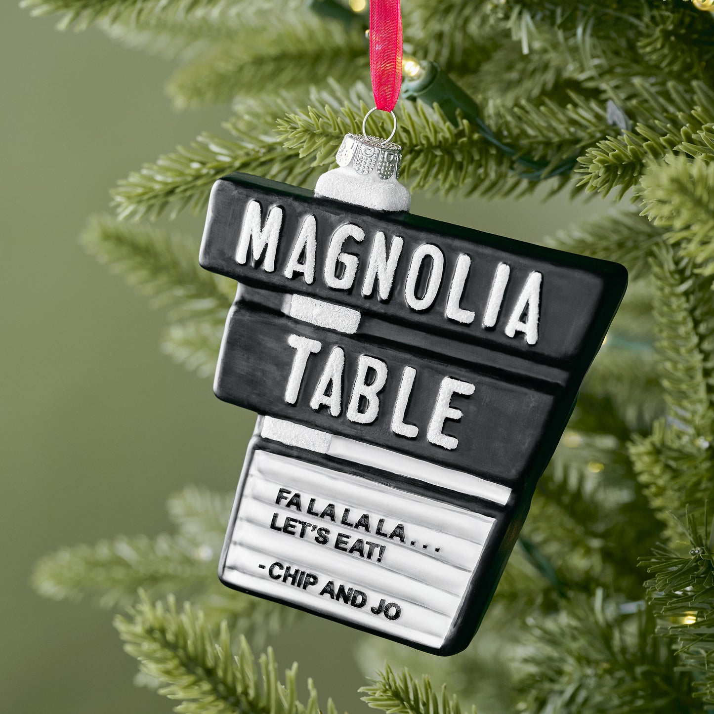 Magnolia Table Blown Glass Ornament shown on tree