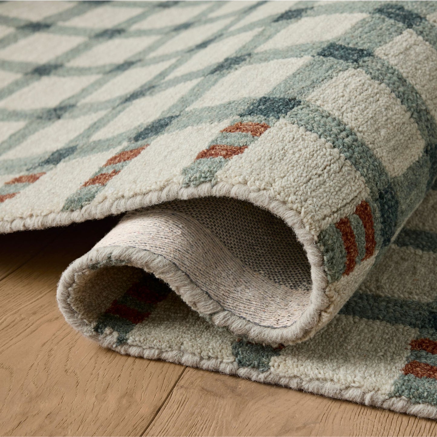 Waylon Spa Brick Rug shown rolled/folded