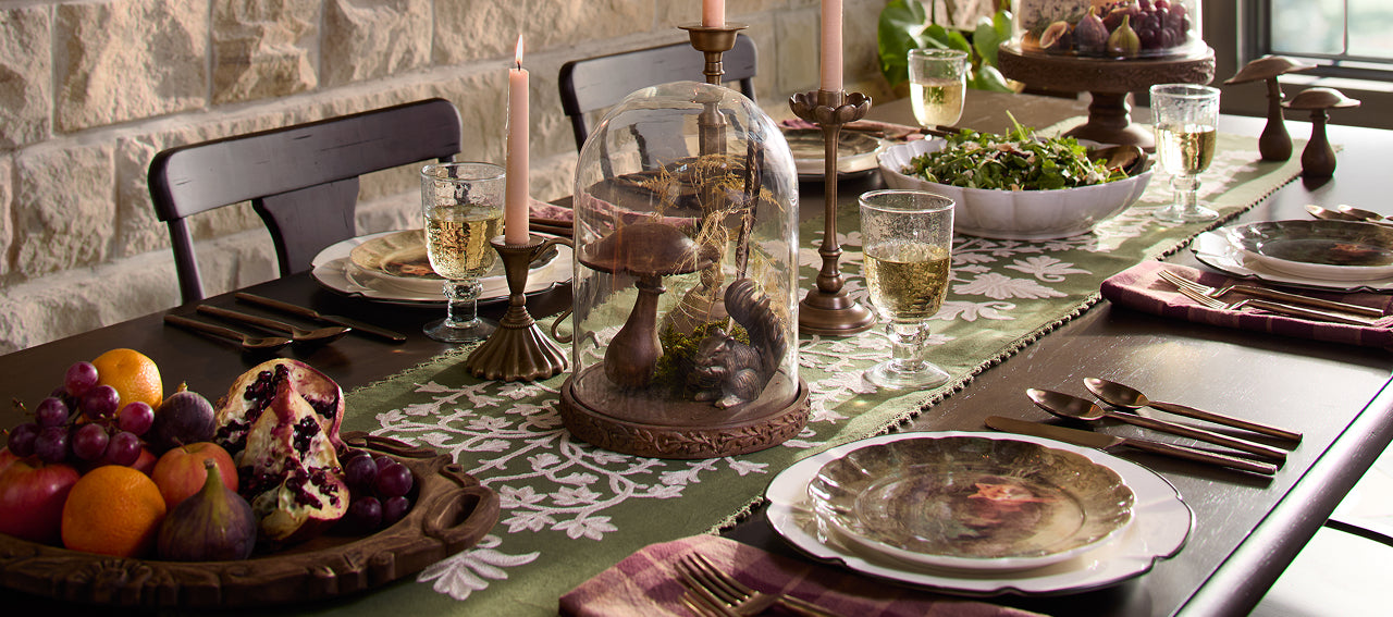 Dining table set for a meal with decorative items and candles.