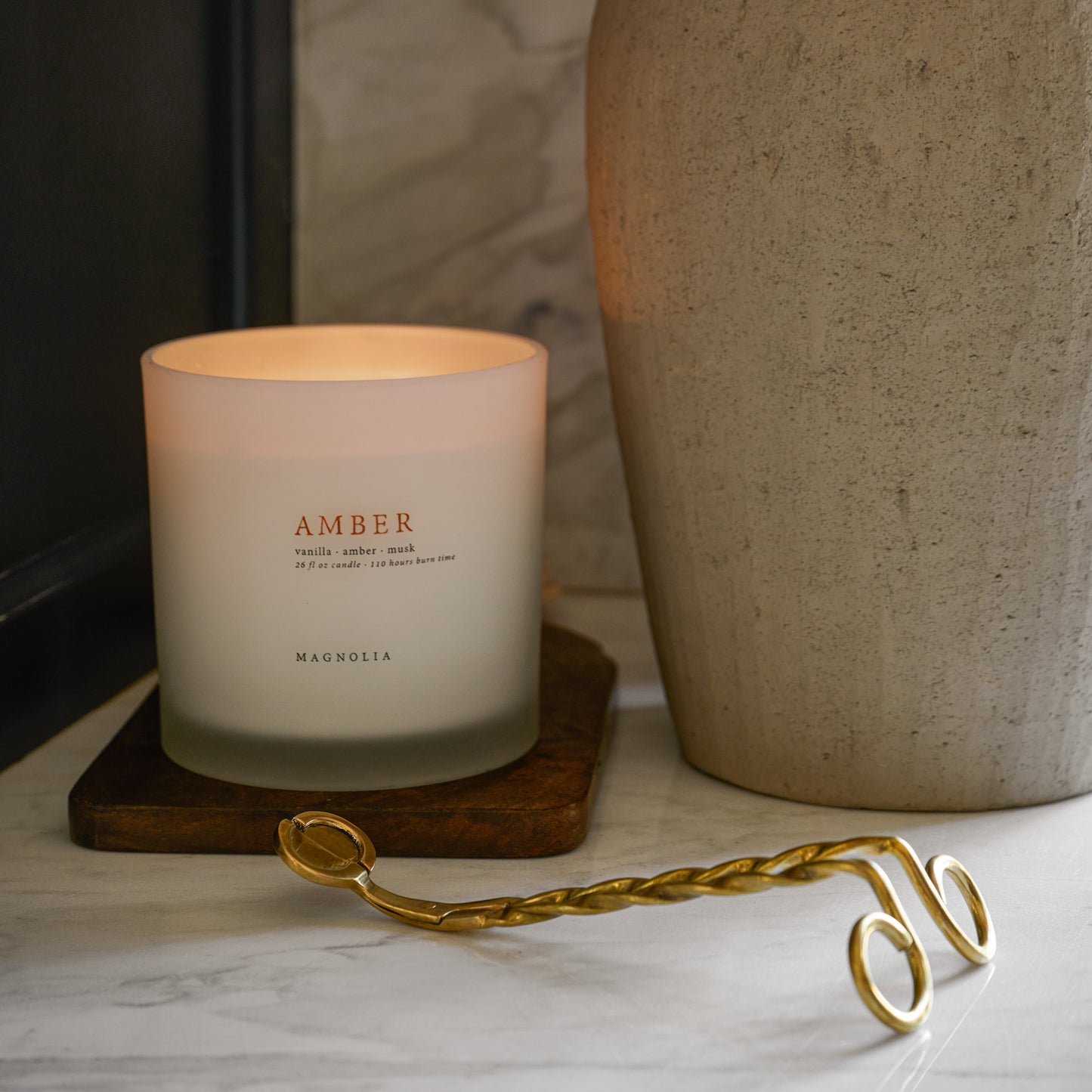 Magnolia Amber Candle next to a large vase