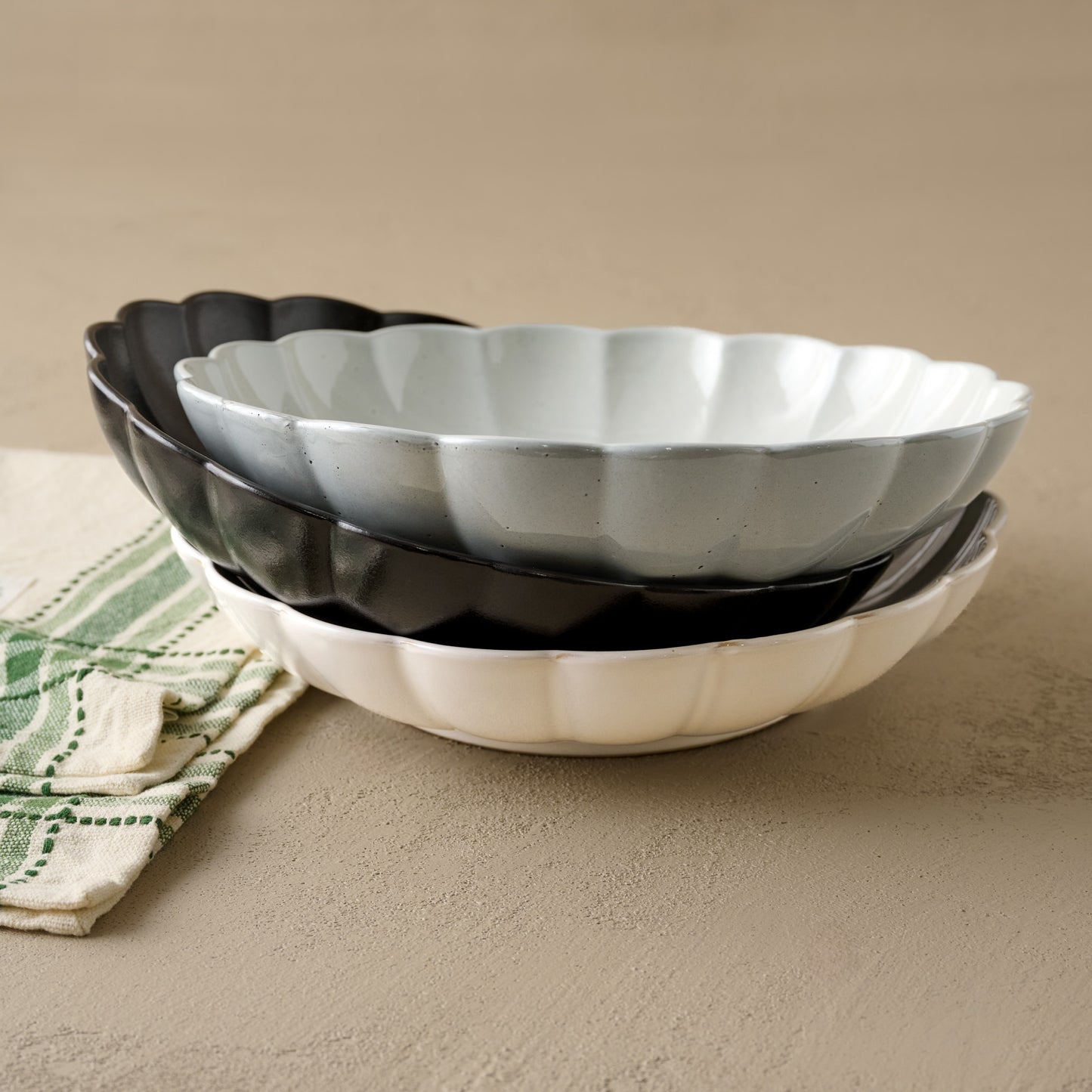 Oversized Cream Scalloped Serving Bowl shown with black and grey oversized scalloped serving bowls