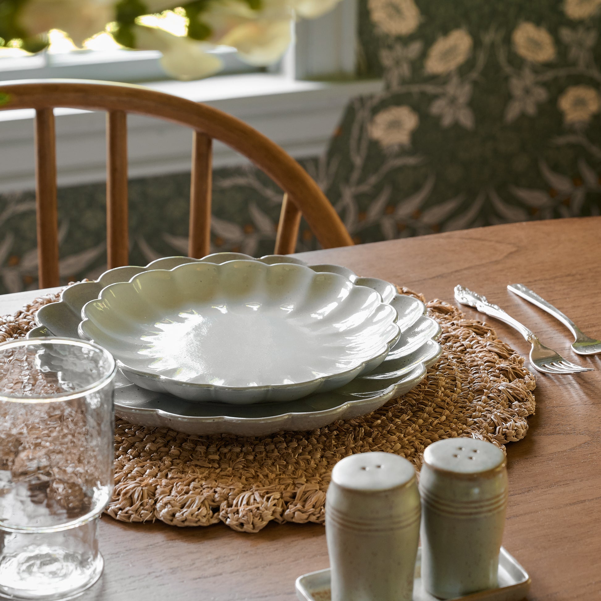 Grey Scalloped Plates stacked on top of a placemat