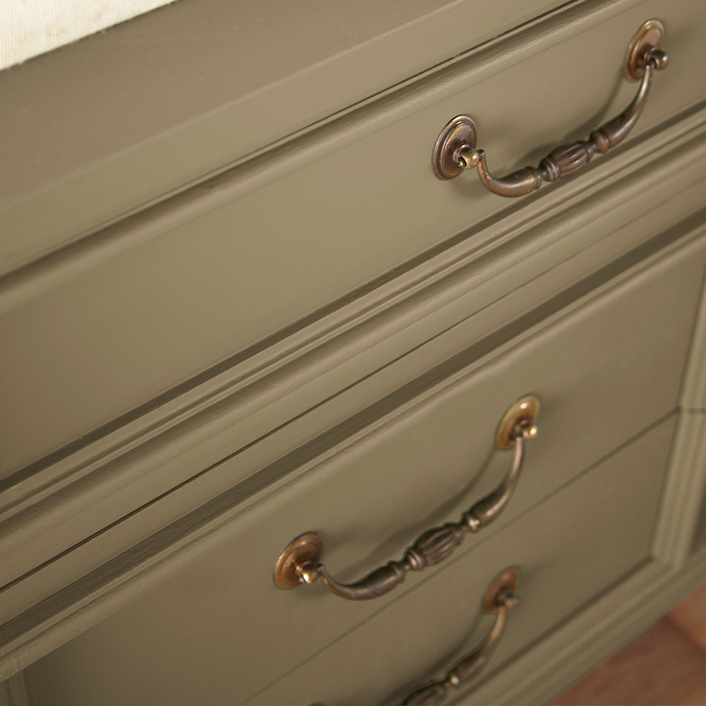 close up view of rich green with brown undertone paint color named remote trail shown painted on cabinet