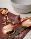 Hammered Copper Measuring Cups on top of tea towel