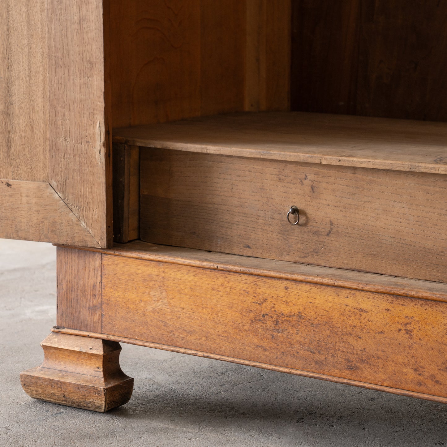 detail view of bottom drawer inside antique wood armoire