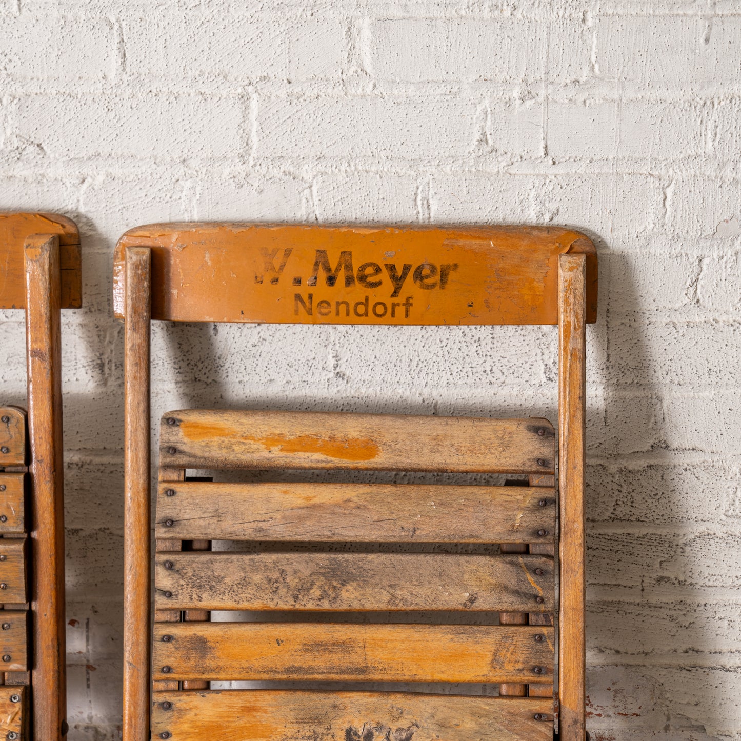 Vintage Wooden German Folding Chair shown up close leaning up against a wall