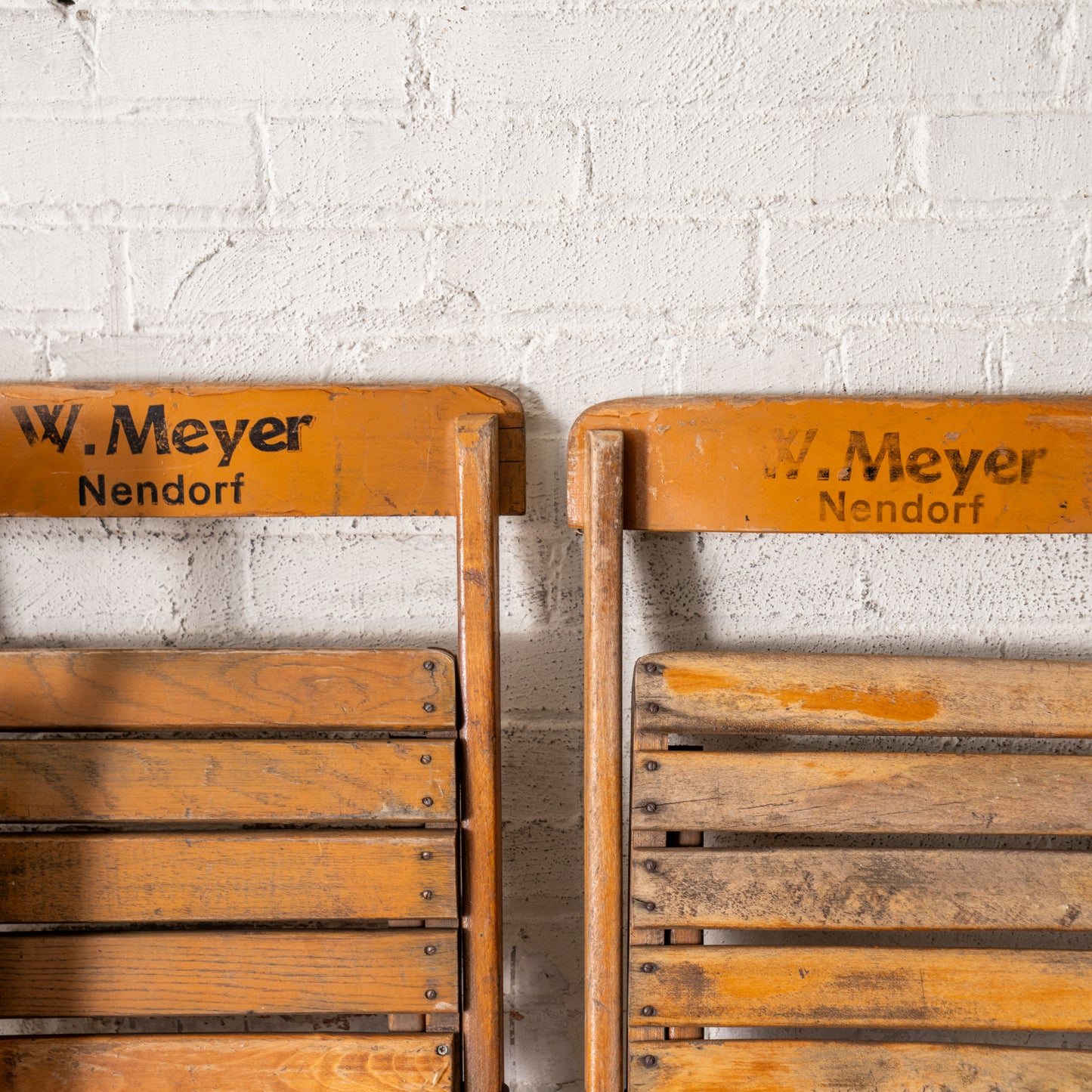 Vintage Wooden German Folding Chairs shown close up leaning against wall