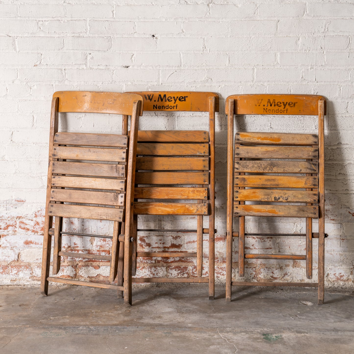 Vintage Wooden German Folding Chairs shown leaning up against wall