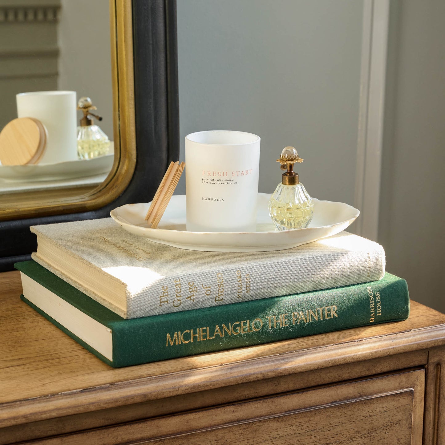 Magnolia Fresh Start Candle shown on stack of books on tray