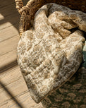 Flora Block Print Quilt - Natural laying inside basket