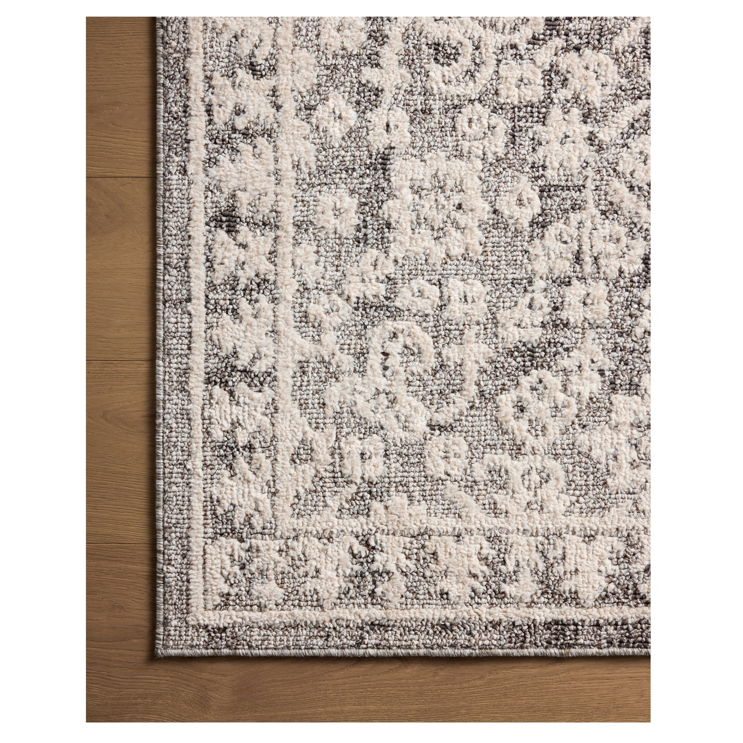 Gigi Grey Ivory Rug close up of corner on wood floor