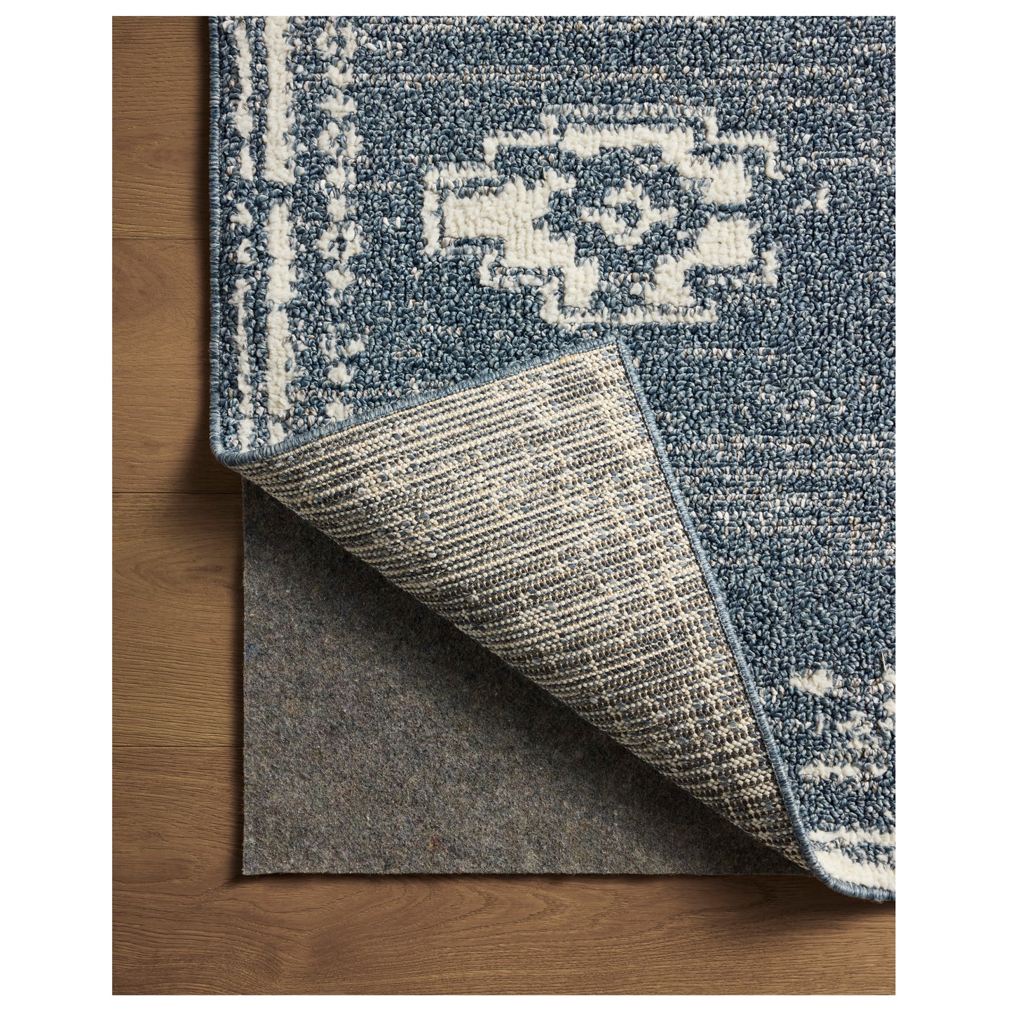 Gigi Denim Ivory Rug close up of corner folded back