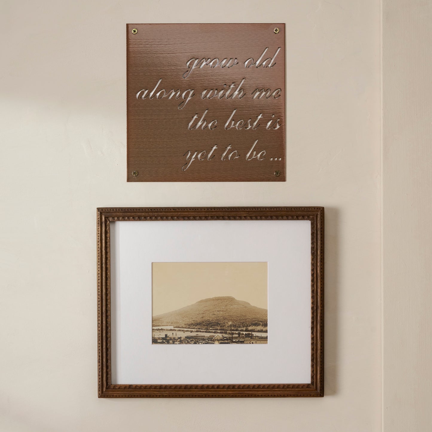 Grow Old Along With Me Sign shown hung on wall above framed image