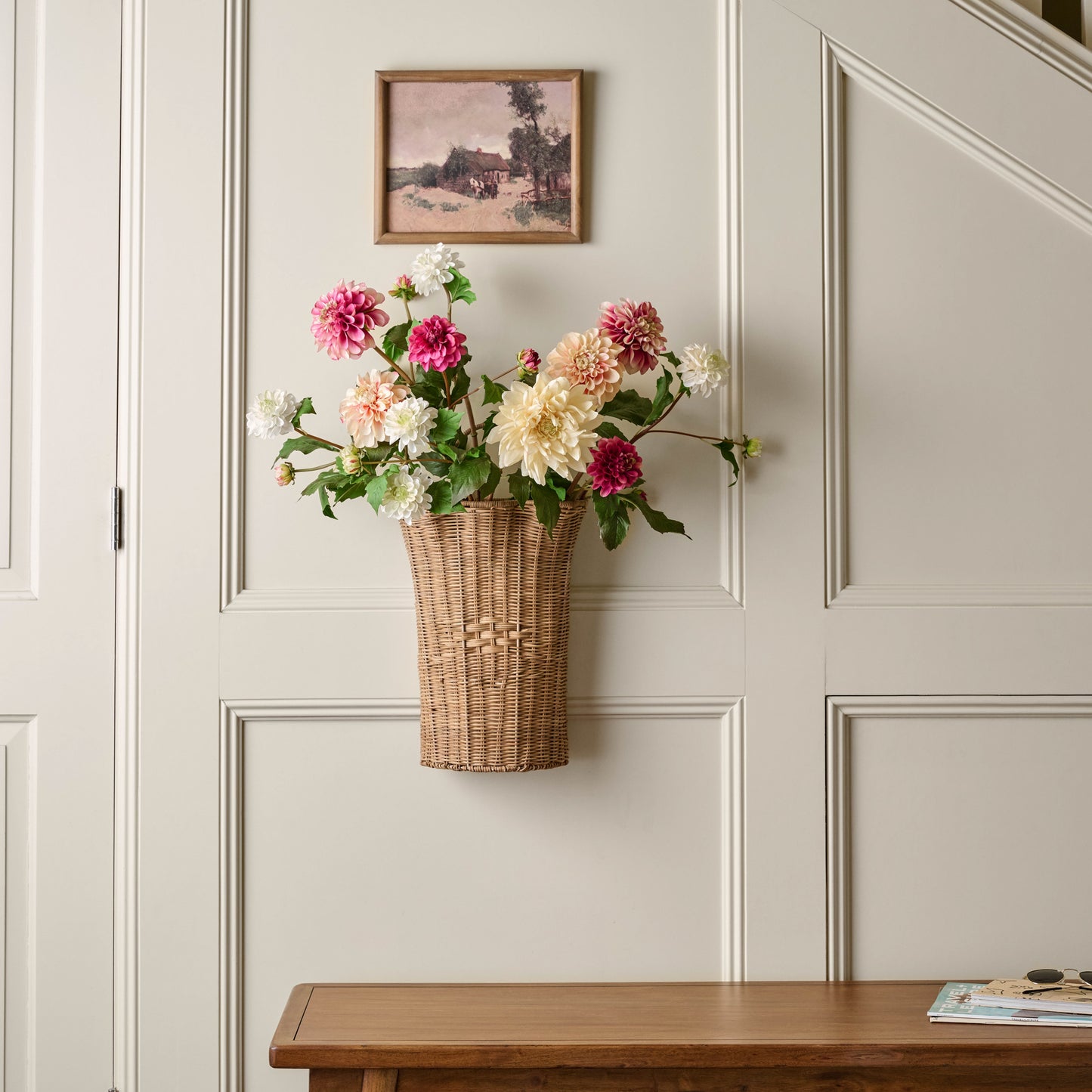 Woven Scalloped Wall Basket hanging on wall with faux dahlia stems