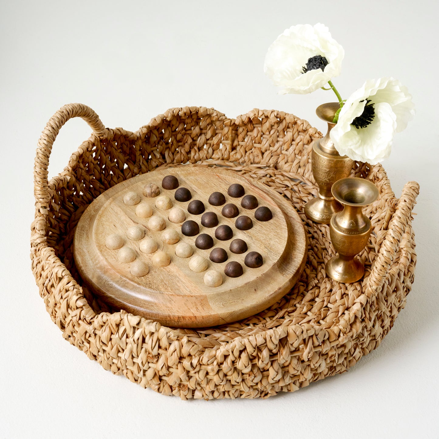 Wooden Solitaire Game Board shown styled on woven tray