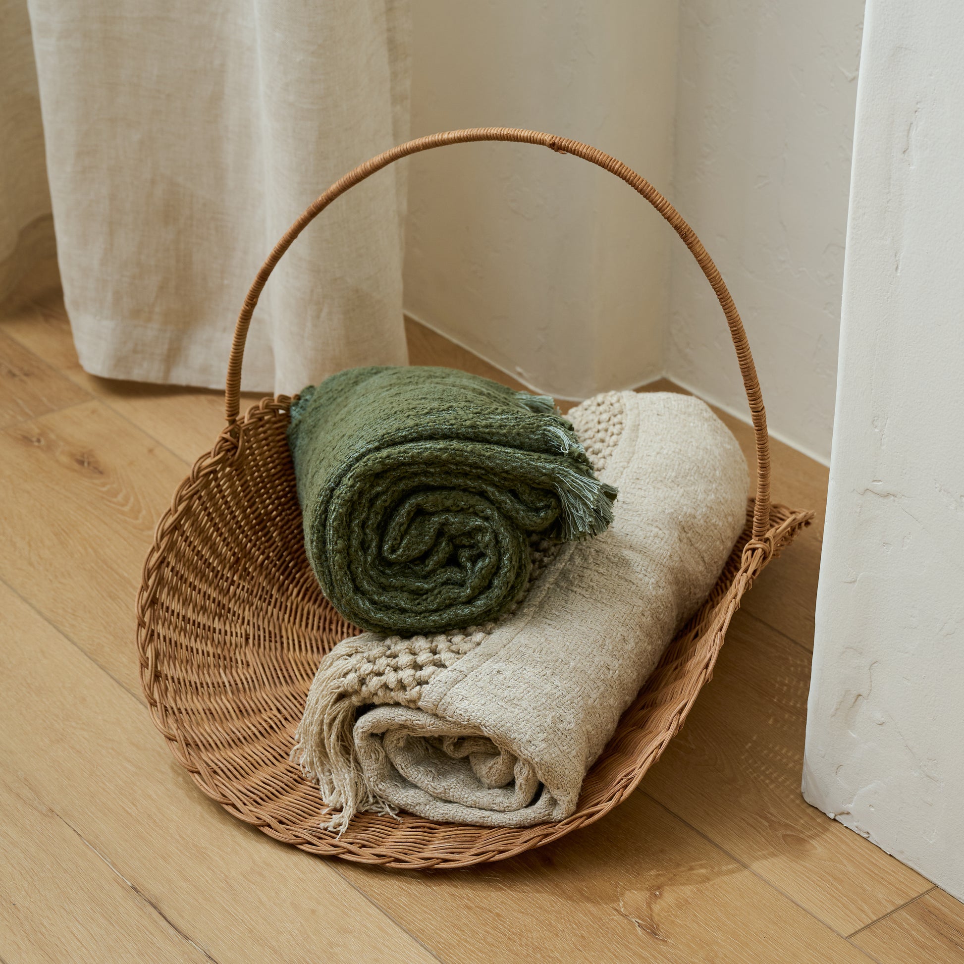 Vintage Inspired Wicker Gathering Basket shown styled with blankets