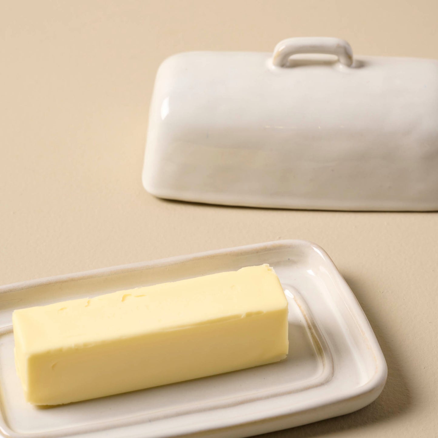 Magnolia Est. Ceramic Butter Dish with butter in it and lid off to the side