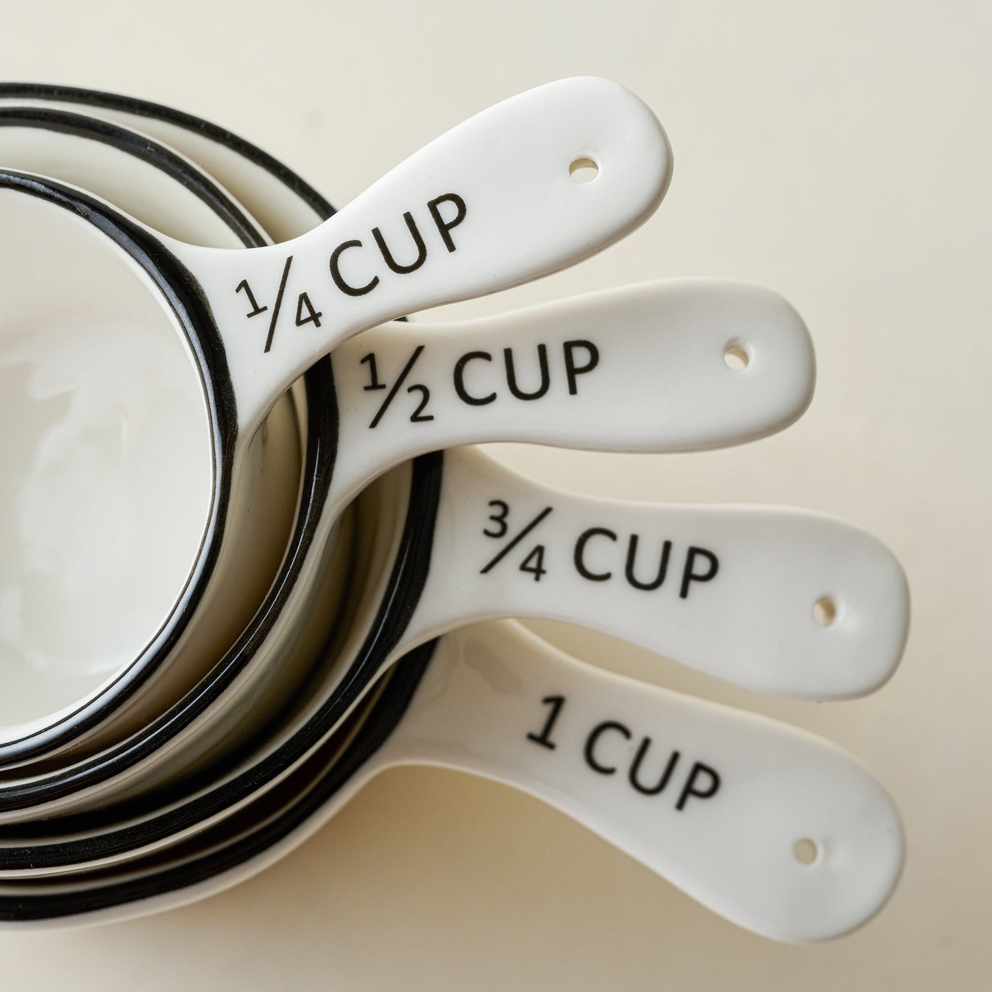 Magnolia Black Rim Ceramic Measuring Cups stacked close up of handles
