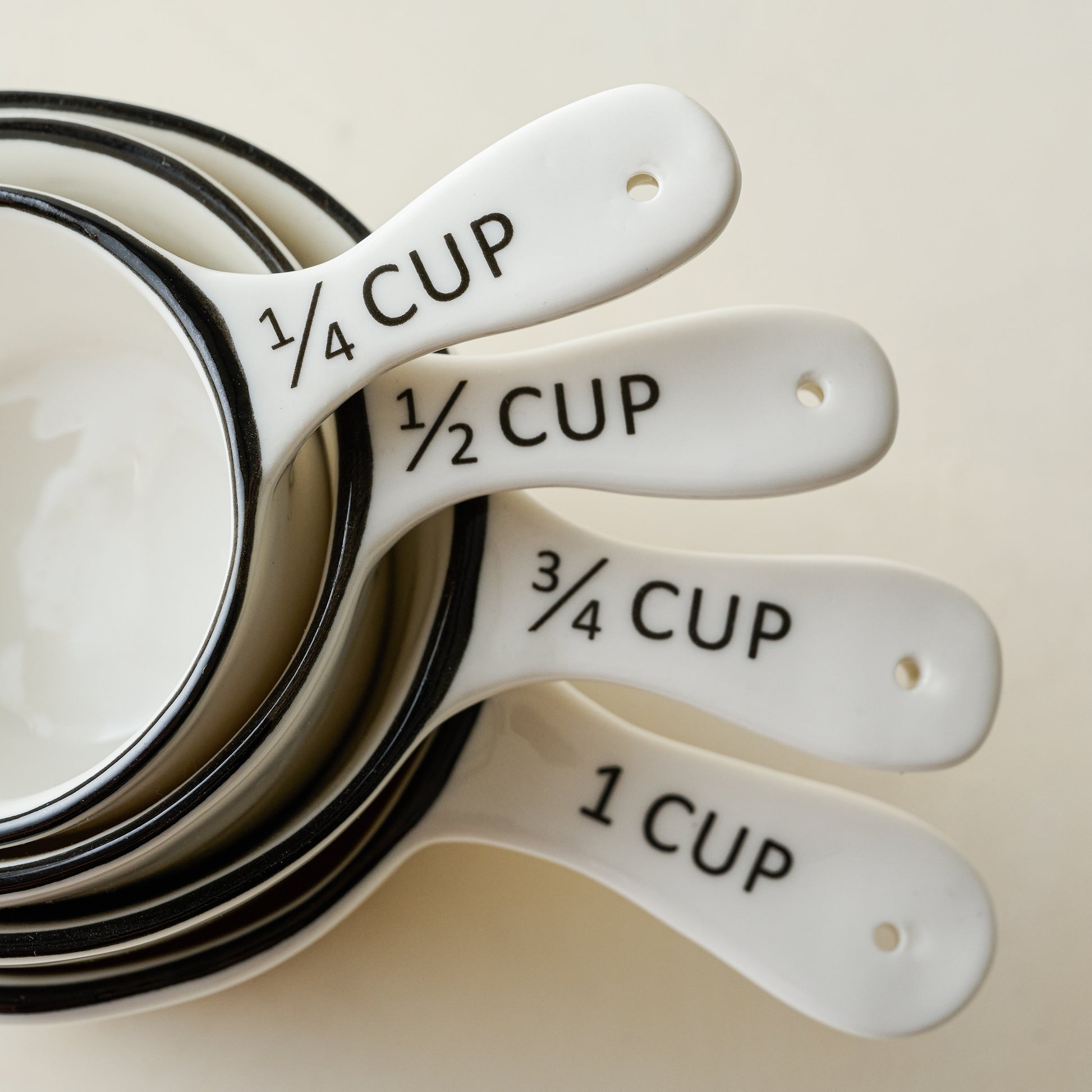 Magnolia Black Rim Ceramic Measuring Cups stacked close up of handles