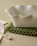 French White Scalloped Loaf Pan shown up close on pot holder