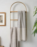 Antique Brass Carmen Wall Ladder against a wall with throw blankets hanging on it