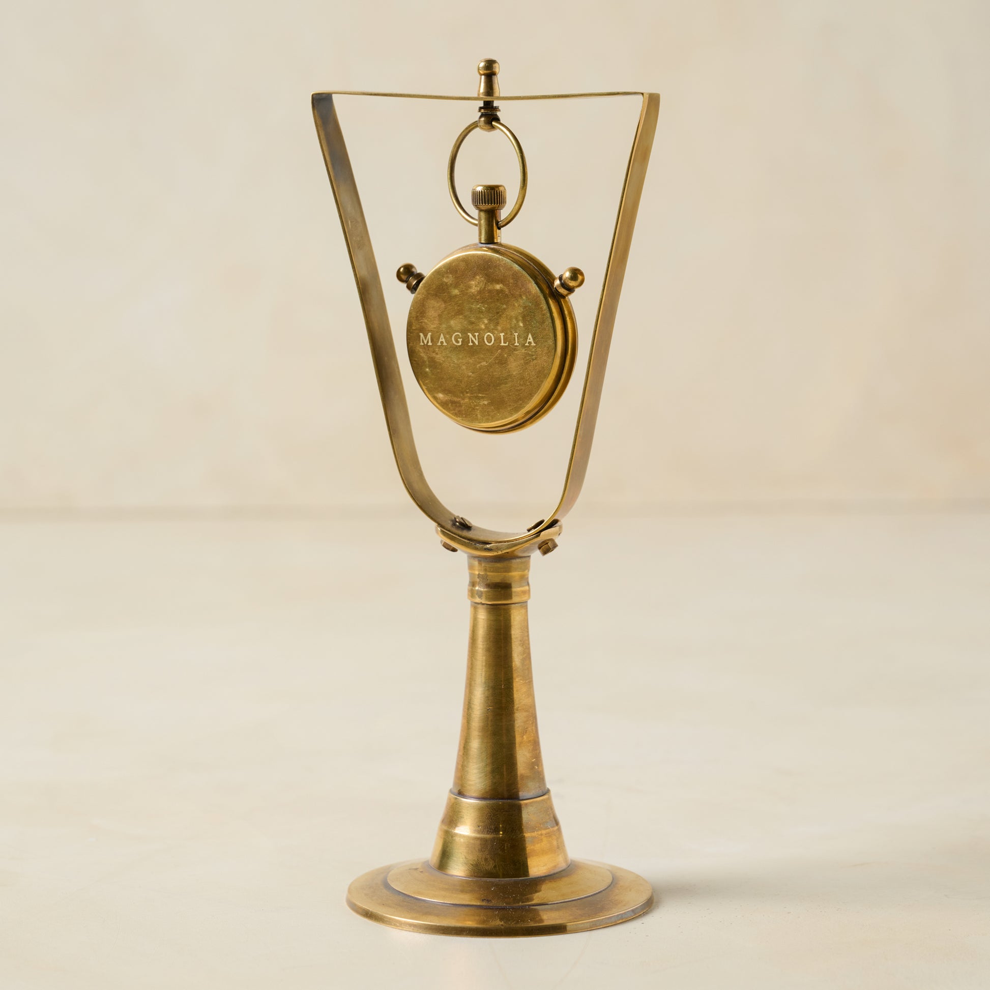 Antique Inspired Hanging Table Clock shows clock turned to the back with magnolia logo on the back of the clock