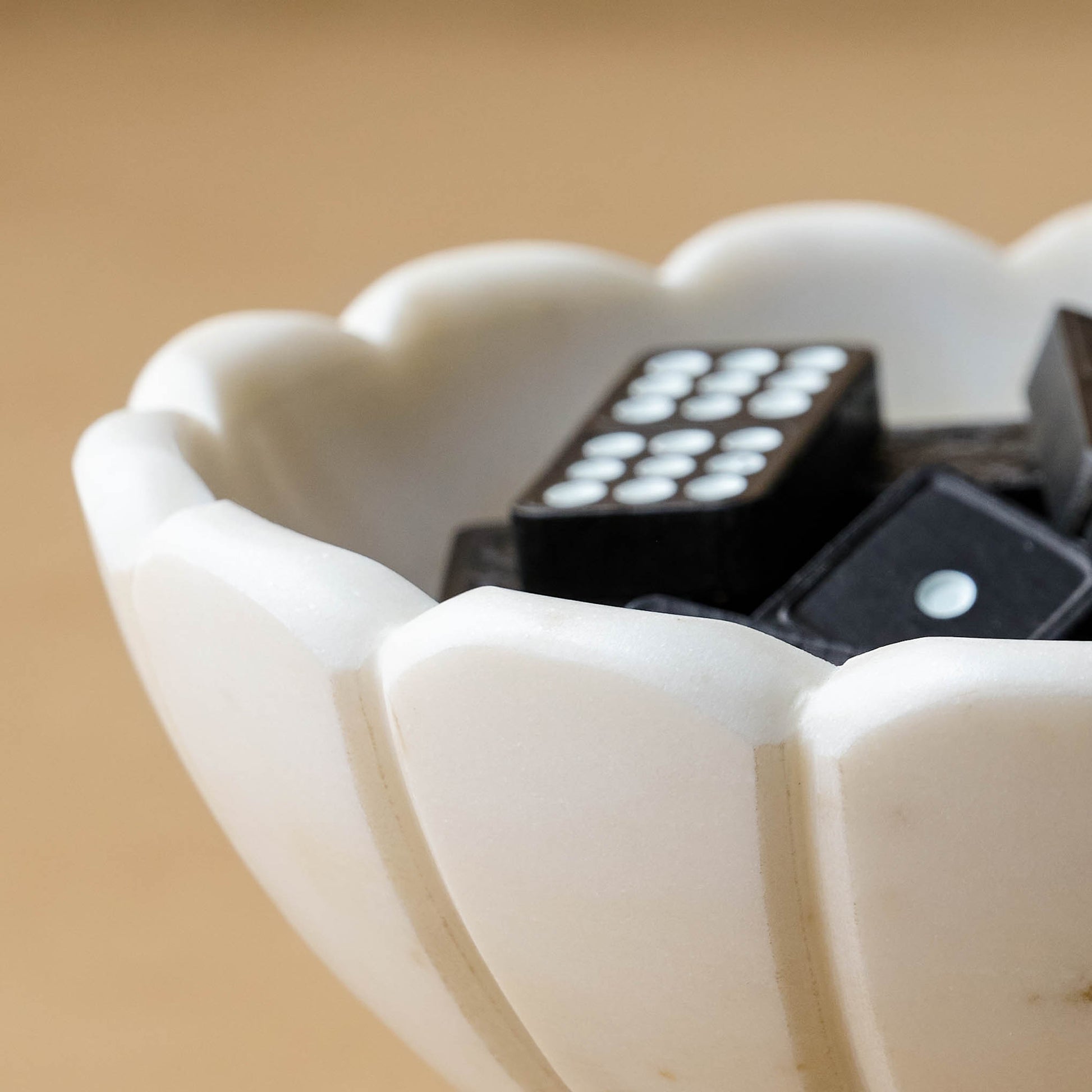 Marble Scalloped Accent Bowl close up and filled with black dominoes