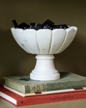 Marble Scalloped Accent Bowl containing dominoes on a bookshelf
