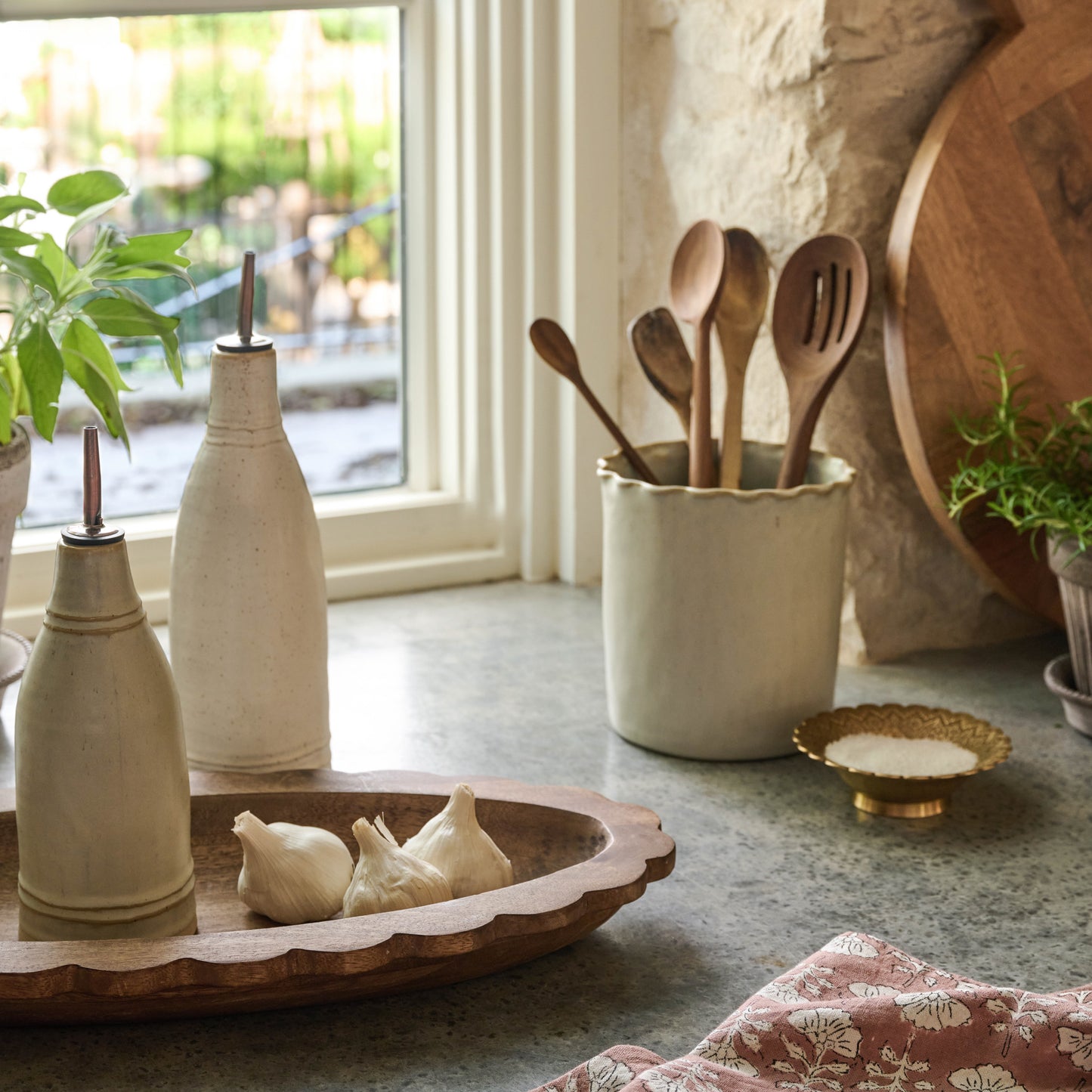 ceramic oil and vinegar pourers sitting on oval antiqued wood tray
