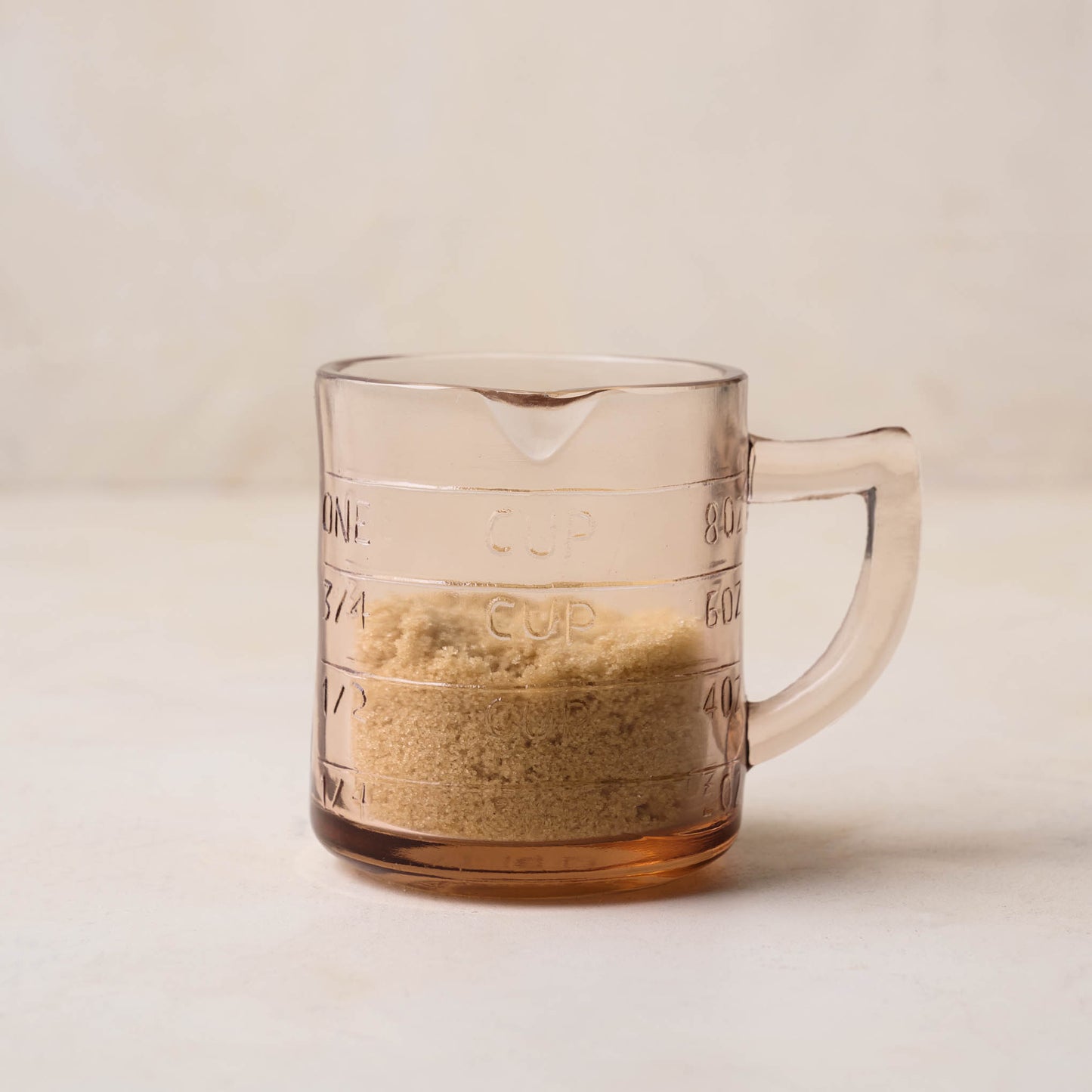 Blush One Cup Glass Measuring Cup containing brown sugar