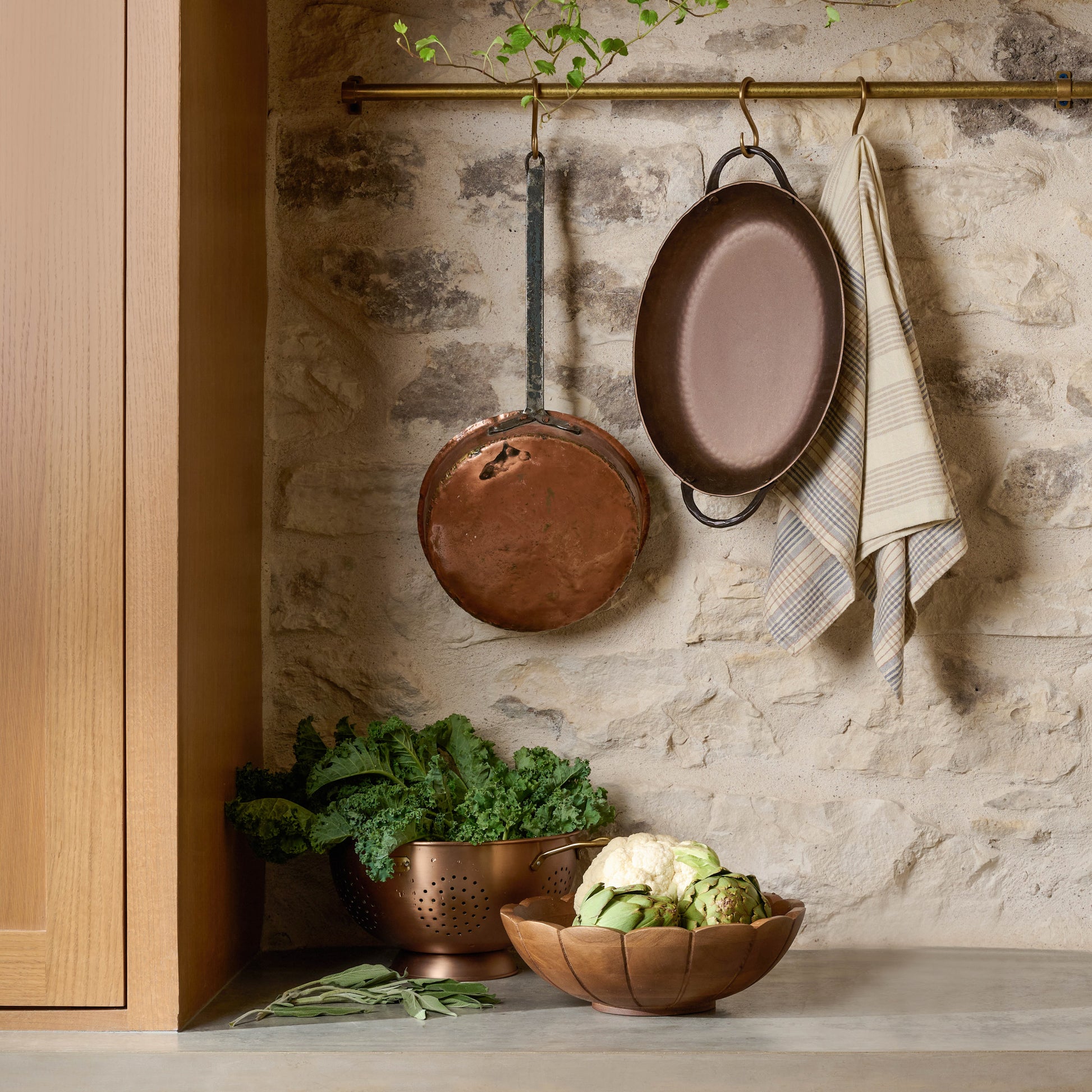 Copper and Brass Colander filled with kale on a kitchen counter