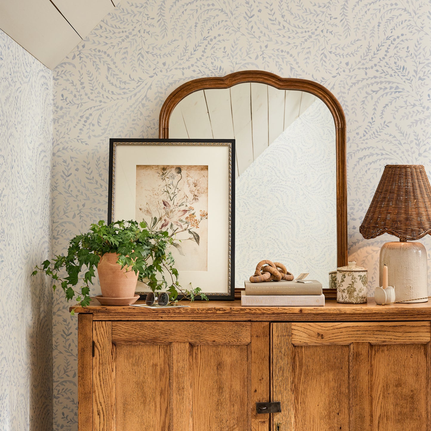 Charlotte Mirror on a sideboard with a lamp, painting, potted plant and decor