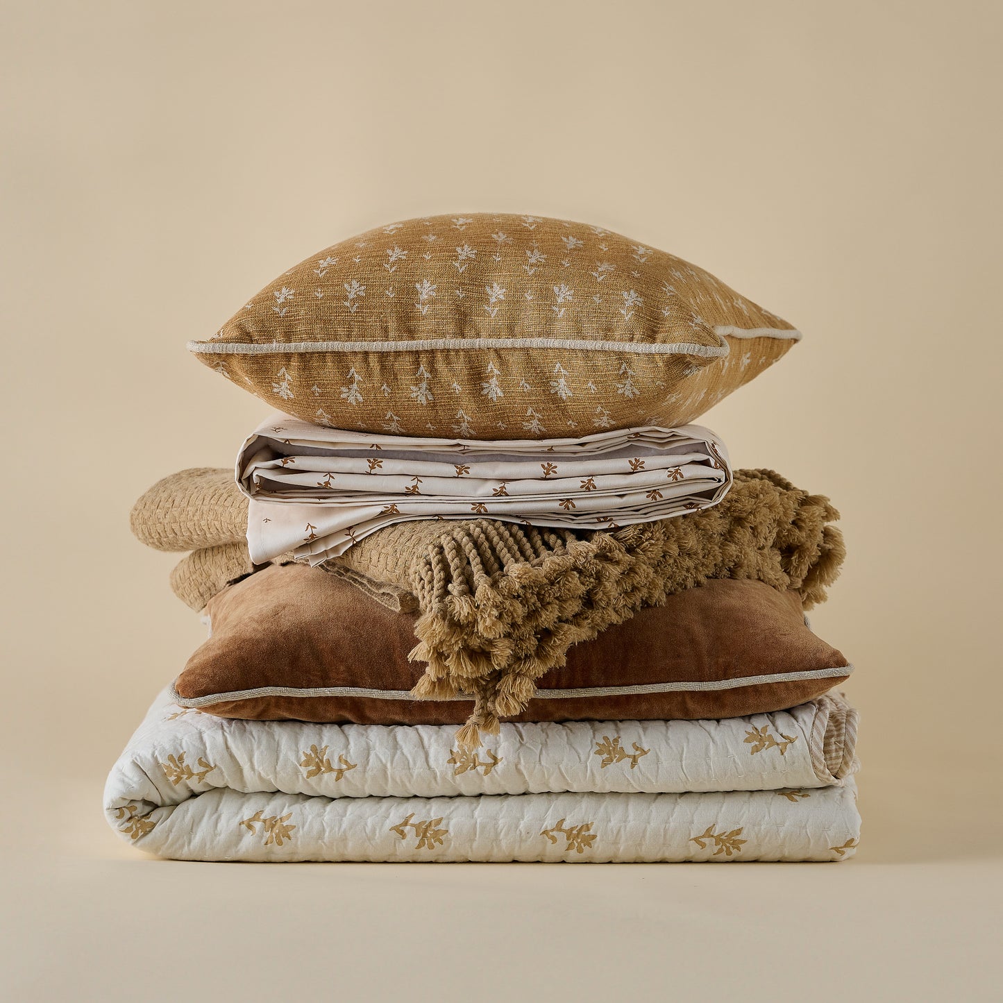 Ochre Basketweave Throw shown in stack of fall bedding