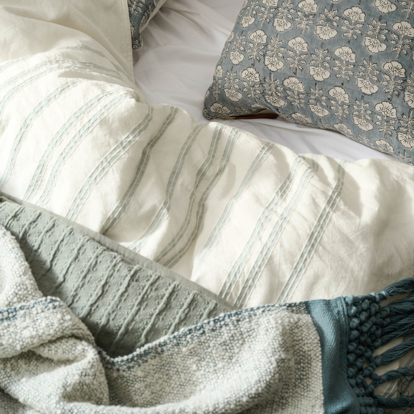 Flora Silver Blue Printed Pillow on a bed