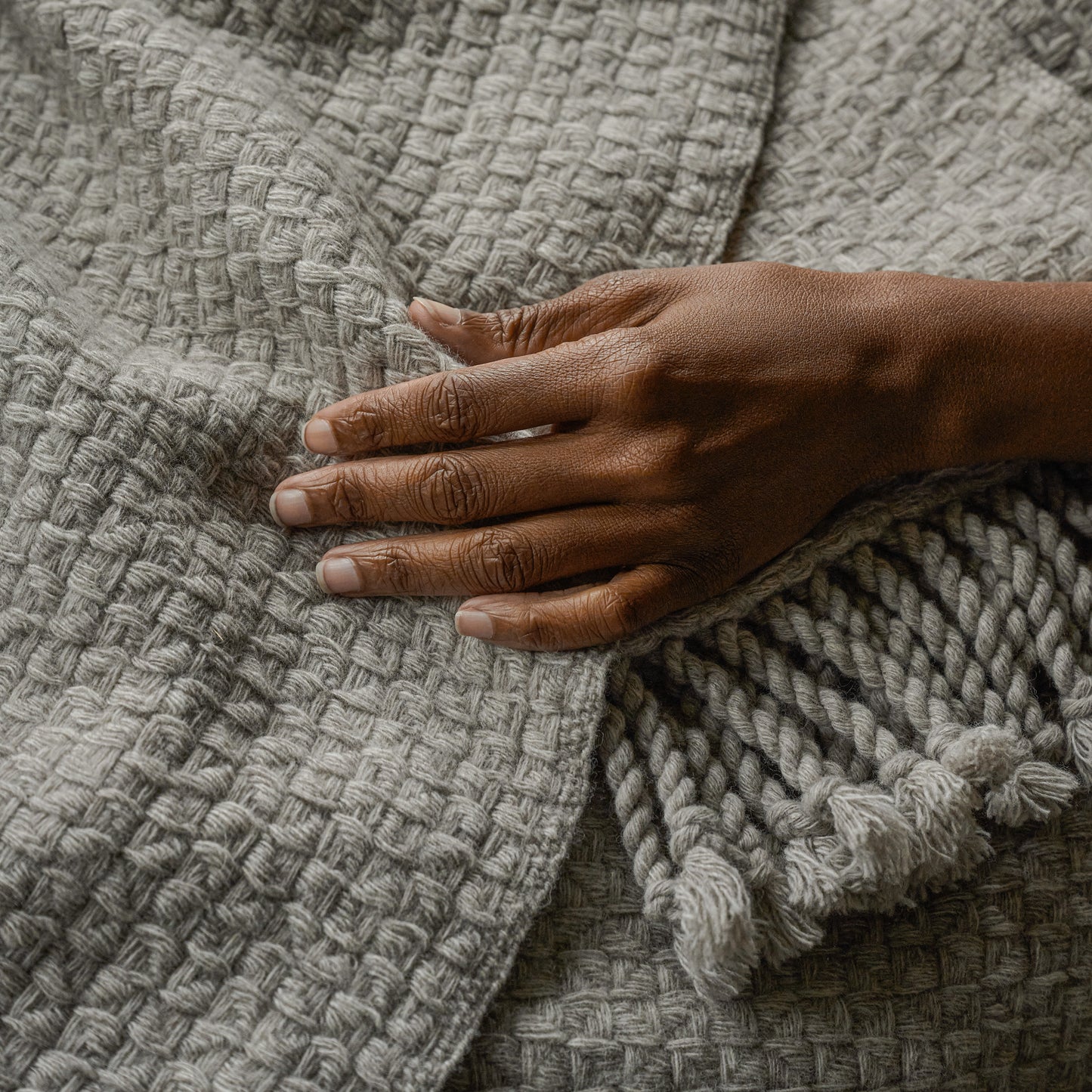 Grey Basketweave Throw shown up close with hand
