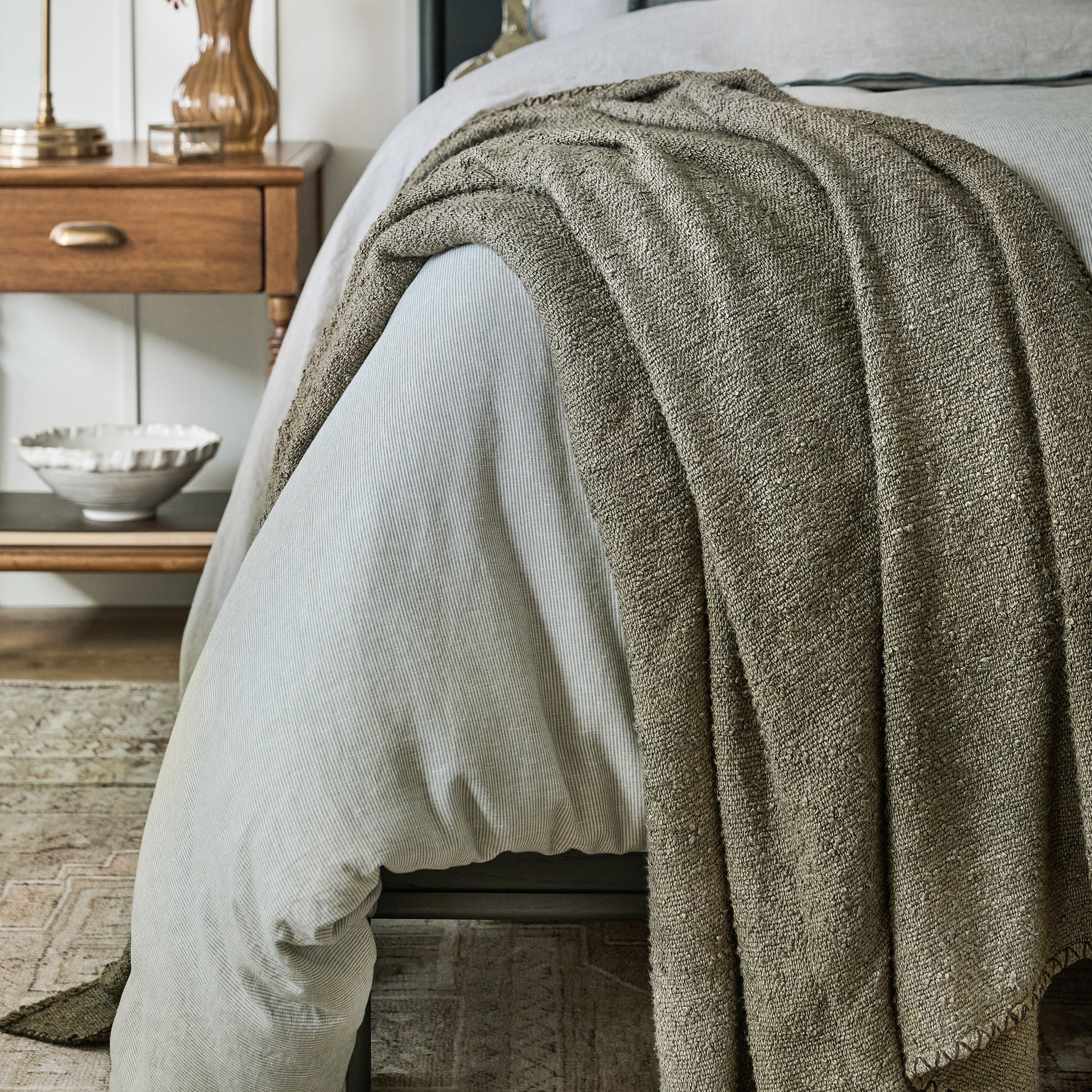 Green Remie Oversized Boucle Throw shown draped over bed