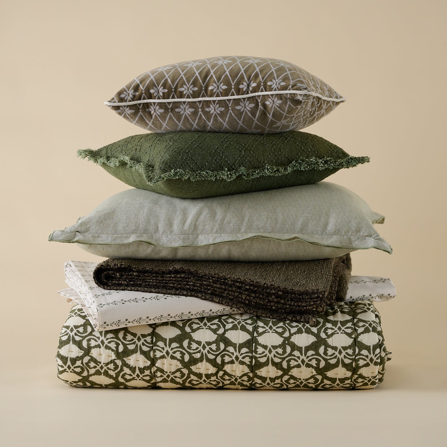 Sylvie Vine Printed Sheet Set shown folded in stack of other bedding and pillows