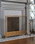 Antiqued Brass Tulip Carved Fireplace Screen shown by fireplace