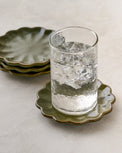 Sage Scalloped Edge Coaster Set of Four shown with glass of water