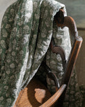 Flora Block Print Quilt - Dusty Green close up hanging over chair