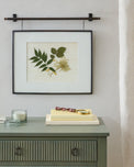 Colleen Antique Bronze Rail Picture Frame shown hung above nightstand