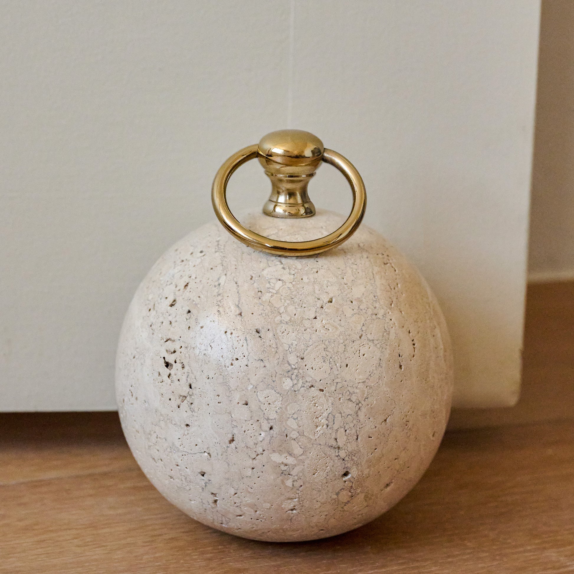 Travertine and Brass Doorstop in a room