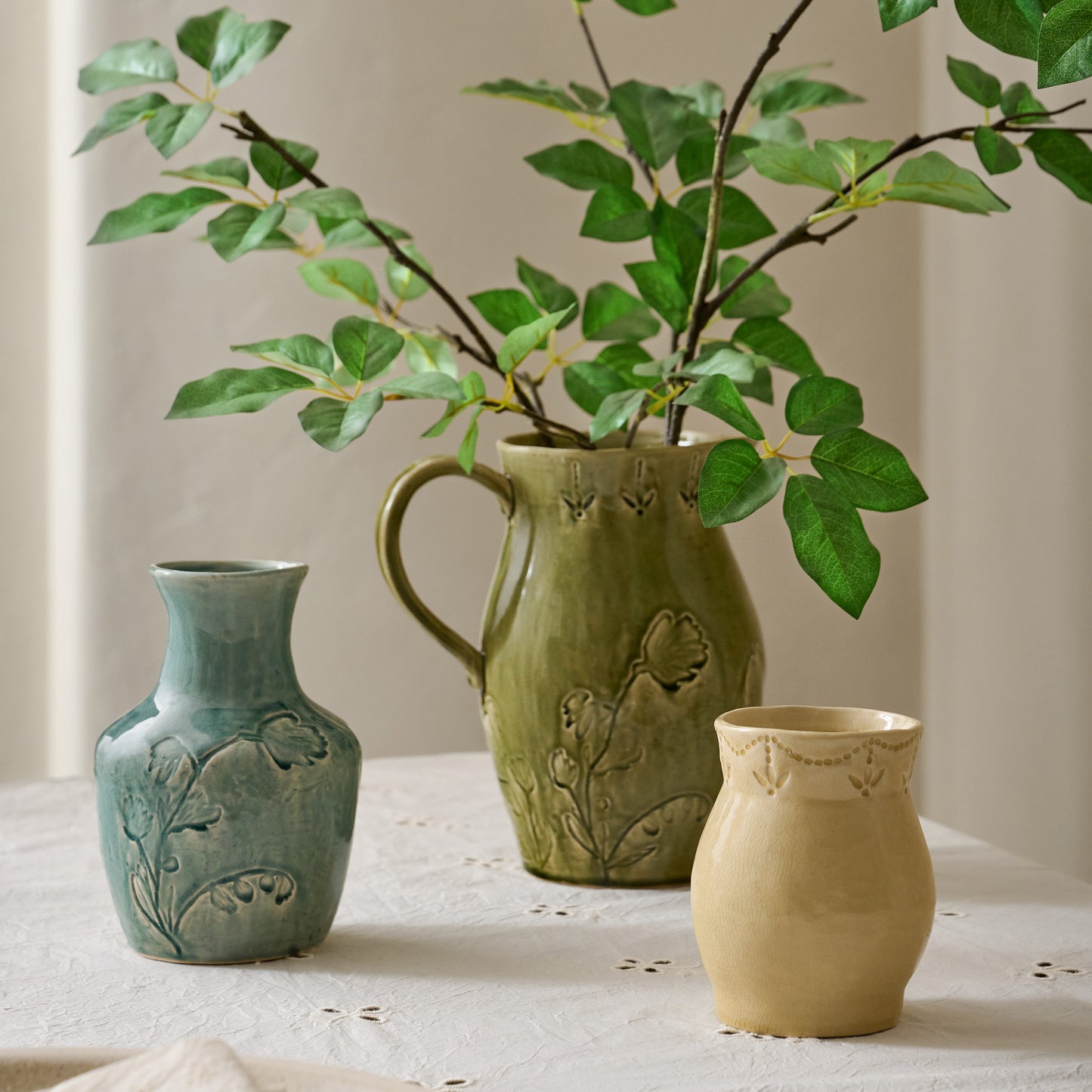 Floral Glazed Ceramic Birdie Vase shown on table with other ceramic vessels