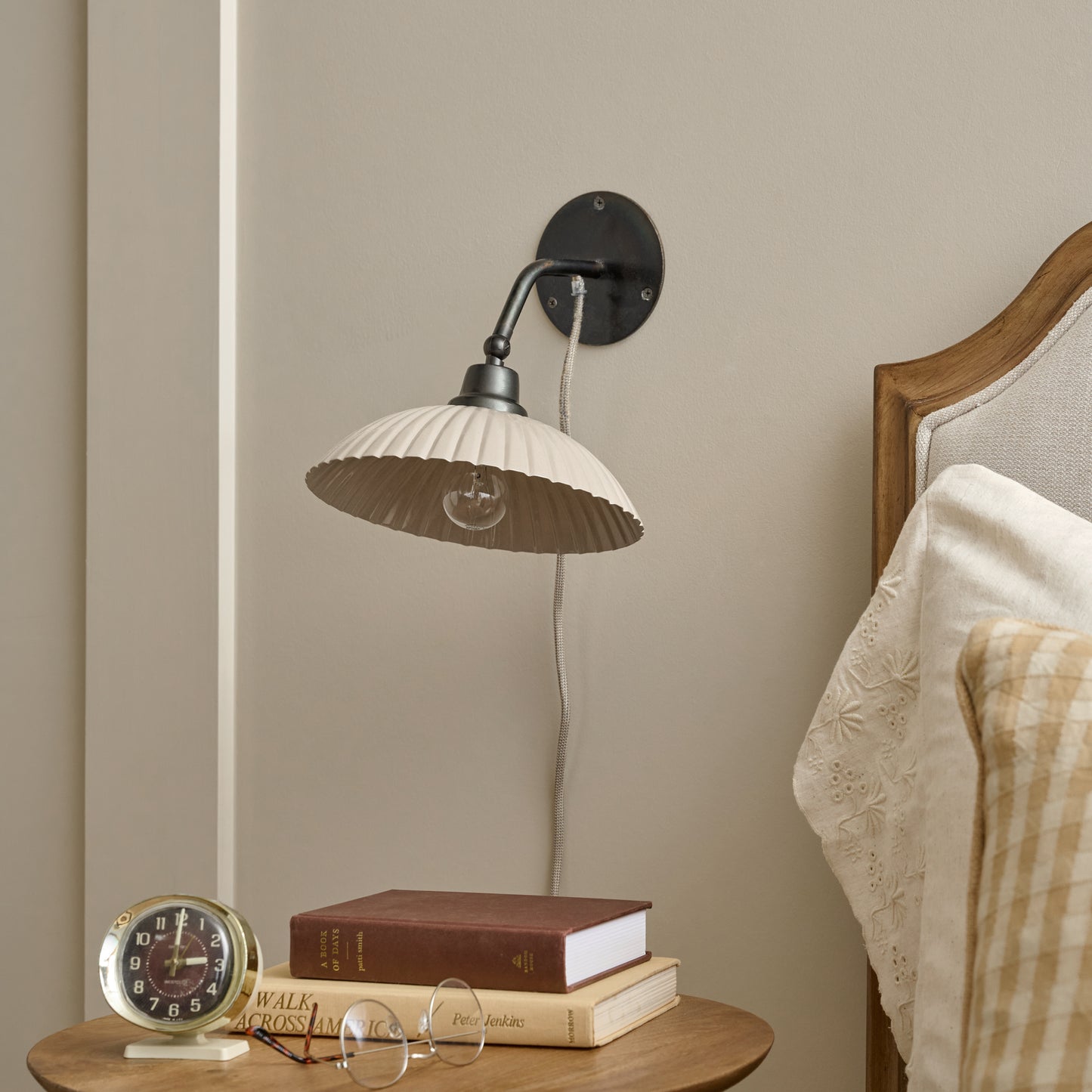 Chester Enamel Plug-in Sconce - Taupe with Bronze shown next to bed